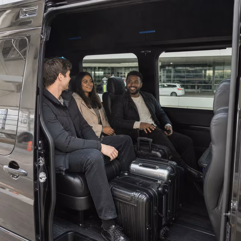 Passengers loading luggage while boarding an Omaha group shuttle