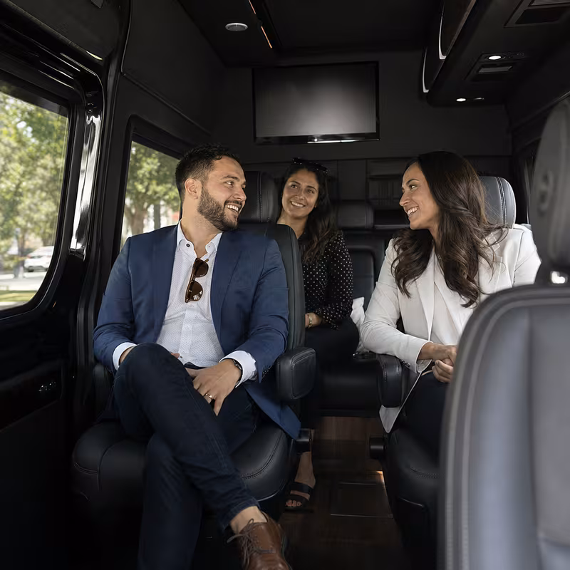 Group boarding a white charter bus for Corporate Transportation transportation in Omaha