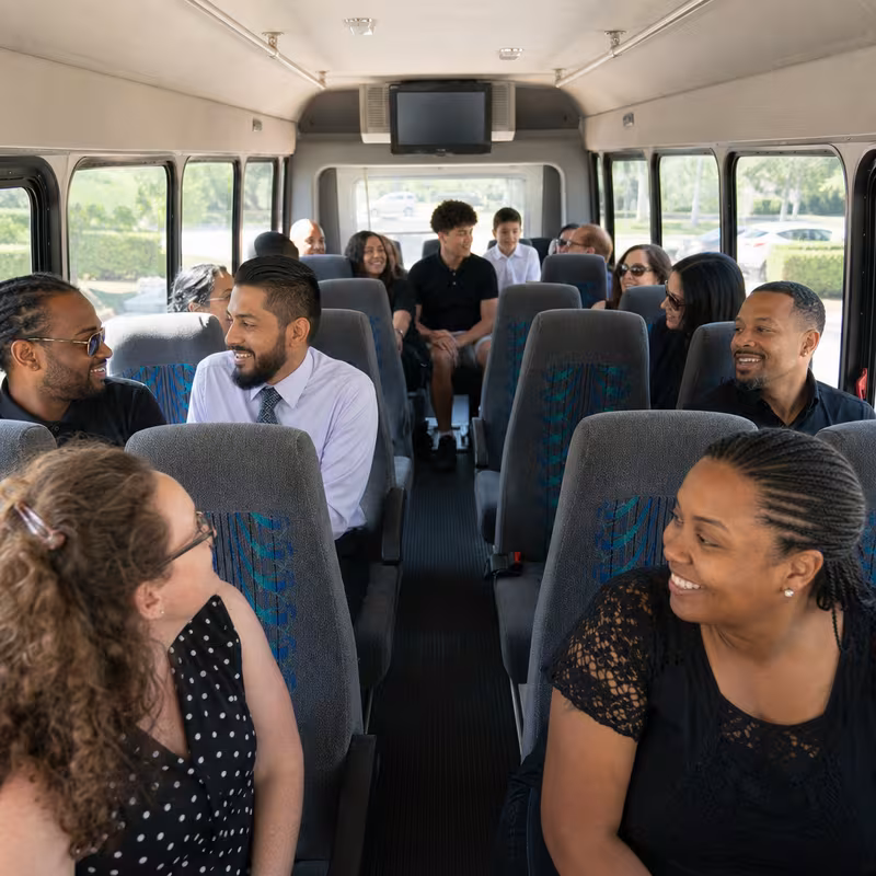 Group boarding a white charter bus for Private Event Transportation transportation in Omaha