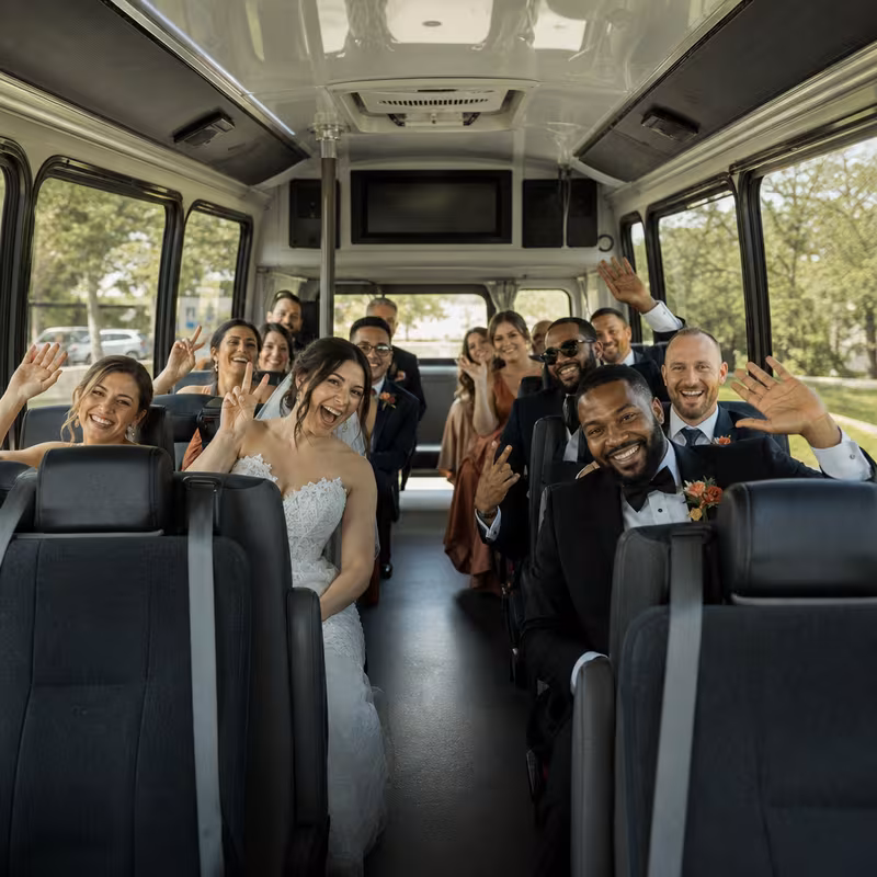 Group boarding a white charter bus for Wedding Transportation transportation in Omaha