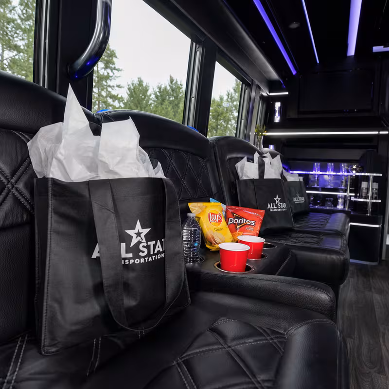 Party bus interior with wraparound leather seating and LED lighting in Omaha